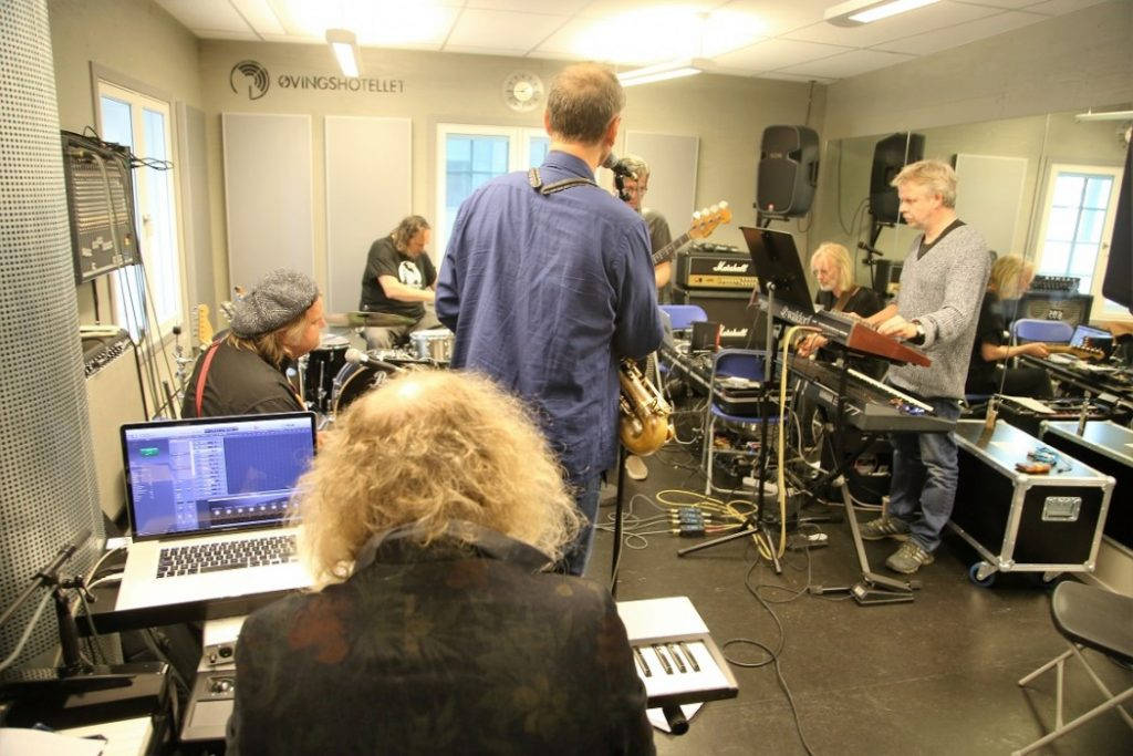 Mange rygger, men øvingslokalet til Bendik og bandet er trangt. Nærmest ser vi bakhodet til Øystein Sevåg, deretter fra venstre Knut Reiersrud, Paolo Vinaccia, Bendik, Audun Erlien, Eivind Aarset og Reidar Skår. Foto: Erik Valebrokk